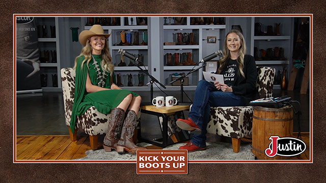 Taylor McAdams has blonde hair and is sitting next to Rebel Sjeklocha with blonde hair, wearing green, looking at the camera, smiling, sitting, and having a conversation.